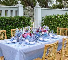 the table is set with blue and pink flowers