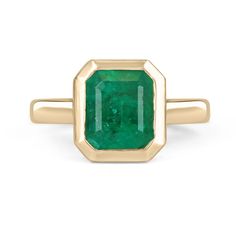 Displayed is a rich medium-dark green Colombian emerald, solitaire, Asscher-cut bezel ring in solid 14K yellow gold. This gorgeous solitaire ring carries a full 2.10-carat EARTH MINED emerald in a sleek and secure bezel setting. The emerald has incredible clarity, color, and luster. Minor imperfections are normal in these gems and make them totally one in the world! This emerald has unique clarity that will have you captivated at first glance. This is an ideal engagement ring or right-hand ring! Elegant Gold Emerald Ring With Smooth Bezel, Faceted Green Emerald Ring, 14k Gold Emerald Ring With Smooth Bezel Gift, Green Emerald-cut Birthstone Ring With Bezel Setting, Green 14k Gold Emerald-cut Rings, Natural Emerald Rings, Emerald Ring Gold, Emerald Cut Rings, Bezel Ring