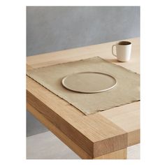 a table with a plate, cup and saucer on it next to a napkin