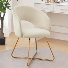 a white chair sitting on top of a rug in front of a potted plant