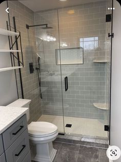 a white toilet sitting next to a walk in shower