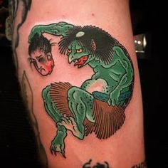 a man with a tattoo on his leg that has an image of a creature and a demon