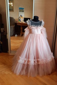 a dress on display in a room with wooden floors and a mannequin's head