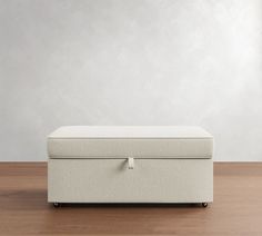 a white ottoman sitting on top of a wooden floor