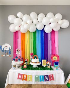 a rainbow themed birthday party with white balloons