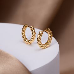 These earrings were designed to add a unique twist to the must-have gold hoop trend. Classic, timeless, and guaranteed to elevate any look. 18K gold-plated Size: 0.6in x 0.6in Snap back hoop closure Hypoallergenic, lead & nickel free If you aren't in LOVE with your purchase, please let us know within 30 days of receiving your item, and you'll receive a stress-free refund. Handcrafted Jewelry Gold, Bubble Bag, Black Gift Boxes, Snap Back, Classic Gold, Stunning Earrings, Gold Hoops, Ear Jewelry, Gold Hoop