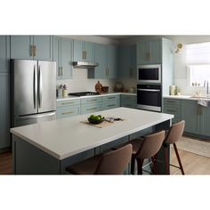 a kitchen with blue cabinets and white counter tops is pictured in this image, there are four chairs at the island