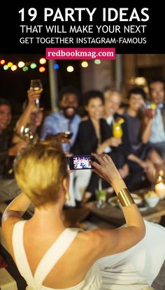 a woman taking a photo with her cell phone in front of a group of people