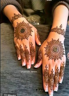 two hands with henna tattoos on them