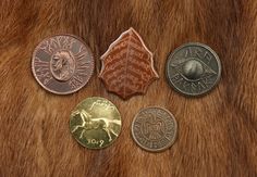 four different types of coins sitting on top of a fur covered surface