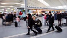 people are walking through an airport with their suitcases and bags in hand as they pull them along