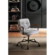 an office chair sitting on top of a hard wood floor next to a book shelf