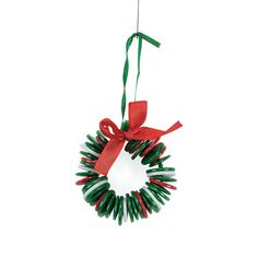 a christmas wreath ornament hanging from a red ribbon on a white background,