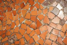 an orange and brown mosaic tile wall