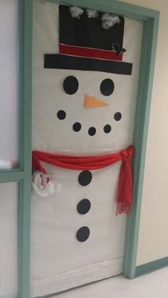 a door decorated with a snowman wearing a top hat and scarf for the holiday season