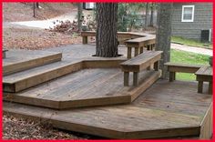 a wooden deck with benches under a tree