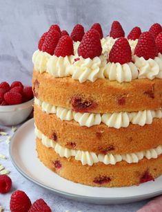 a cake with white frosting and raspberries on top