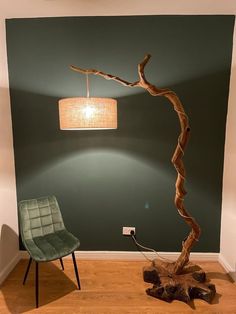 a lamp that is on top of a table next to a chair and tree trunk