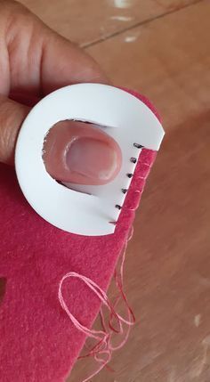 a hand holding a red cloth with a small white object in it's center