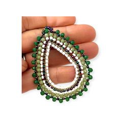 These handmade, green beaded hoop earrings are perfect for anytime. The richly hued shades bring out the color of any outfit. The effect is a concentration of color and interest, sure to turn heads. The earrings come in an array of greens from rich deep forest to light celery complimented by white and iridescent beads for an unusual pattern. The dark green frames the outer side of the tear shaped hoop transitioning to the lighter green, followed by the white with the inner part of the hoop which in turn is framed by the iridescent beads. One of the original artists we discovered created these beautiful statement earrings. He is from a family of talented artists. While we love his talent and the beautiful, creative pieces he makes its - it is his beaming smile and the obvious joy in what he Green Beaded Hoop Earrings For Gift, Green Hoop Earrings With Colorful Beads, Bohemian Green Beaded Earrings With Colorful Beads, Green Faceted Bead Dangle Earrings, Green Faceted Beaded Dangle Earrings, Green Bohemian Beaded Earrings, Bohemian Green Beaded Earrings, Green Beaded Dangle Hoop Earrings, Green Hoop Earrings With Dangling Beads For Gift