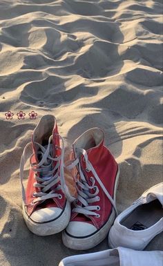 two pairs of shoes sitting in the sand