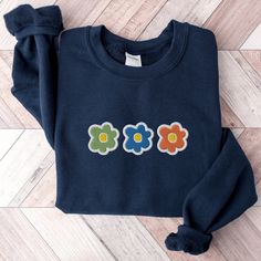 Spring Flower Sweatshirt, Embroidered Flowers Crewneck Sweatshirt, Colorful Flower Shirt, Cute Floral Sweatshirt, Spring Embroidered Shirt This embroidered flower crewneck sweatshirt is everything. Perfect to wear for spring! Please let me know if you would like extended sizing (3X-5X), I have certain color and size options available! ✨ 50% cotton, 50% polyester ✨ Pre-shrunk ✨ Classic fit Care: Machine wash: cold (max 40C or 105F) Tumble dry: low Do not iron directly on the design REFUNDS AND EX Long Sleeve T-shirt With Multicolor Embroidery, Blue Embroidered T-shirt For Fall, Long Sleeve Tops With Multicolor Embroidery, Casual Multicolor Embroidered Sweatshirt, Blue Tops With Custom Embroidery For Spring, Multicolor Long Sleeve Tops With Embroidered Graphics, Casual Long Sleeve T-shirt With Multicolor Embroidery, Embroidered Cotton Blue Sweatshirt, Multicolor Floral Embroidered Crew Neck T-shirt