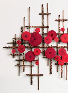 a sculpture made out of sticks and red buttons