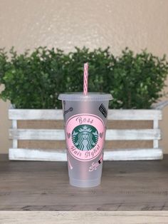 a starbucks cup sitting on top of a wooden table