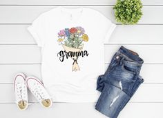 A perfect, personalized tee for any mom, grandmother, or auntie - this graphic tee features your choice of birth month flower for a totally personalized and custom gift! Choose your month(s) and I'll bring to life a custom birth flower bouquet complete with the name of the recipient front and center. This is a one of a kind, unique gift that would make any Mother's Day surprise complete! Product Details: This short sleeve tee is professionally printed from my original drawing! Bella short sleeve Personalized Short Sleeve T-shirt For Spring, Personalized Relaxed Fit T-shirt As Gift, Personalized Summer T-shirt For Gift, Personalized T-shirt For Spring Gift, Personalized White Top For Spring, Spring Family Matching Personalized T-shirt, Personalized Casual Spring T-shirt, Personalized Casual T-shirt For Spring, Medium Long