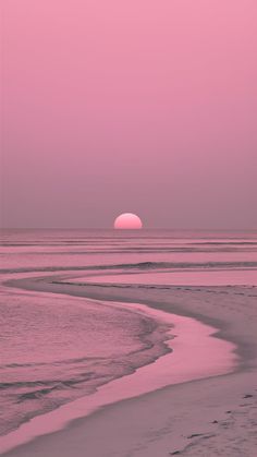 the sun is setting over the ocean with pink sky and water in the foreground