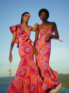 two women in dresses standing next to each other