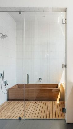 a bath tub sitting inside of a bathroom next to a walk in shower and wooden floor