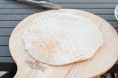 two pita breads sitting on top of a wooden cutting board