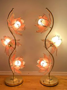 two lamps that are sitting on top of a table with flowers in the shape of leaves