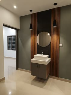 a bathroom with a sink, mirror and two lights on the wall next to it