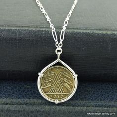 This is a custom order item. Your necklace will ship within 3-5 business days of payment confirmation. This German 10 Reichspfennig rests in a hand-crafted setting made of recycled sterling silver wire. I make each setting by hand separately from the coin. The setting is stamped with my maker's and metal purity (925) mark on the interior of the bail. The coin does not have a hole drilled in it or any metal soldered to its edge. The pendant is attached to a sterling silver chain. The chain is ava Vintage Sterling Silver Jewelry For Commemoration, Vintage Sterling Silver Coin Jewelry, Antique Sterling Silver Coin Necklace, Vintage Sterling Silver Coin Necklace In Silver, Antique Handmade Coin Necklace As Gift, Handmade Antique Coin Necklace As Gift, Antique Handmade Coin Necklace For Gift, Vintage Silver Coin Necklace Gift, Handmade Antique Coin Necklace For Gift