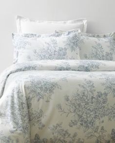 a bed with blue and white flowers on it