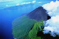 an island in the ocean surrounded by clouds