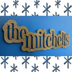 the mitchells logo on a blue wall with snowflakes in the back ground