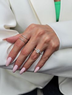 a woman's hand with pink manicured nails and a ring on her finger