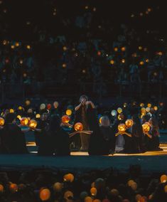 a group of people standing on top of a stage with pumpkins in front of them