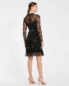 This exquisite dress features delicate sheer long sleeves that add a touch of allure, while intricate embellishments create a captivating sparkle. The flattering midi length makes it perfect for cocktail parties, formal events, or special occasions. Mac Duggal Embellished mesh overlay; 100% polyester lining Fully-lined bodice; sheer sleeves High neckline Long sleeve Floral embellishments with beaded detailing Ruffled/detailed hem Approx. 40" from top of shoulder to bottom hem Available in Black Elegant Sequin Dress With Sheer Sleeves For Party, Long Sleeve Midi Dress For Gala, Glamorous Festive Midi Dress For Formal Occasions, Glamorous Festive Formal Midi Dress, Long Sleeve Evening Midi Dress For Wedding, Long Sleeve Midi Dress For Evening Wedding, Glamorous Festive Cocktail Midi Dress, Festive Elegant Gala Midi Dress, Festive Glamorous Cocktail Midi Dress