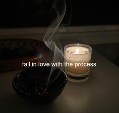 a candle and bowl on a table with the words fall in love with the process