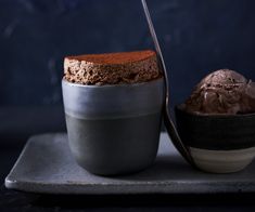 two desserts are sitting on a plate and one has a spoon in the bowl