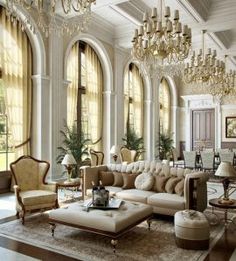 an elegant living room with chandeliers and large windows