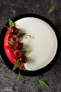 a cake with cherries and leaves on top