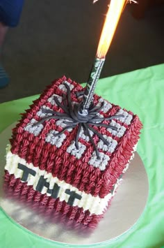 a red and white cake with a sparkler on top