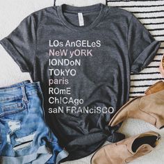 City Shirt, Major City List TShirt, Vintage graphic shirt, Travel Shirt, Cities Tee, Travel Lover Gift, Gift for Pilot Shirt Looking for additional travel or outdoor apparel? Check these out: https://www.etsy.com/shop/TheGraphicPeach?ref=seller-platform-mcnav§ion_id=31675954 Our shop uses direct-to-garment printing to make our products. The design ink is sprayed on, then allowed to soak into the fibers of the garment. This process yields fine quality prints and a smooth finish on the garment. BELLA + CANVAS T SHIRT The Bella + Canvas 3001 t-shirt feels soft and light, with just the right amount of stretch. It's comfortable and the unisex cut is flattering for both men and women. We can't compliment this shirt enough - it's one of our crowd favorites. And it's sure to be your next favorite Trendy Crew Neck T-shirt With Name Print, Casual Cotton Transfers With Text Print, Graphic Tee With Name Print Short Sleeve, Graphic Tee With Letter Print Crew Neck, Graphic Tee Shirt With Letter Print And Crew Neck, Trendy Short Sleeve T-shirt With Name Print, Casual Tri-blend Shirt With Text Print, Graphic Tee With Name Print And Crew Neck, Graphic Tee Shirt With Text Print Short Sleeve