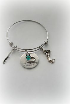 "Hand-Stamped Personalized Cheerleader Bangle Bracelet Bracelet features a custom-stamped name disc along with 2 charms of your choice (if you do not select charms -the stamper will choose) and a Swarovski channel Birthstone drop. Fashioned on a stainless steel expandable bangle. Adult and Children's Sizes Available Please include in the \"Notes to Seller\" box: ♥ Name ♦ ♦ ♦ ♦ ♦ ♦ ♦ ♦ ♦ ♦ ♦ ♦ ♦ ♦ ♦ ♦ ♦ ♦ Only one side can be stamped as it shows through on reverse side. ♦ ♦ ♦ ♦ ♦ ♦ ♦ ♦ ♦ ♦ ♦ ♦ ♦ Personalized Bangle Charm Bracelet For Mother's Day, Personalized Pink Bangle Charm Bracelet, Mother's Day Nickel-free Stainless Steel Charm Bracelet, Personalized Name Charm Bracelet, Adjustable, Ballet Charm Bracelet, Harley Davidson Gifts, Motorcycle Keychain, Coach Jewelry, Cheer Coaches