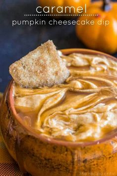 an orange bowl filled with peanut butter and a piece of bread sticking out of it